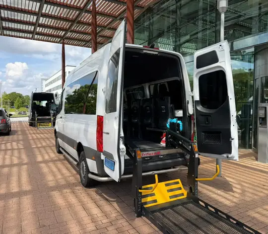 Professionele rolstoeltaxi chauffeur helpt klant in Bussum